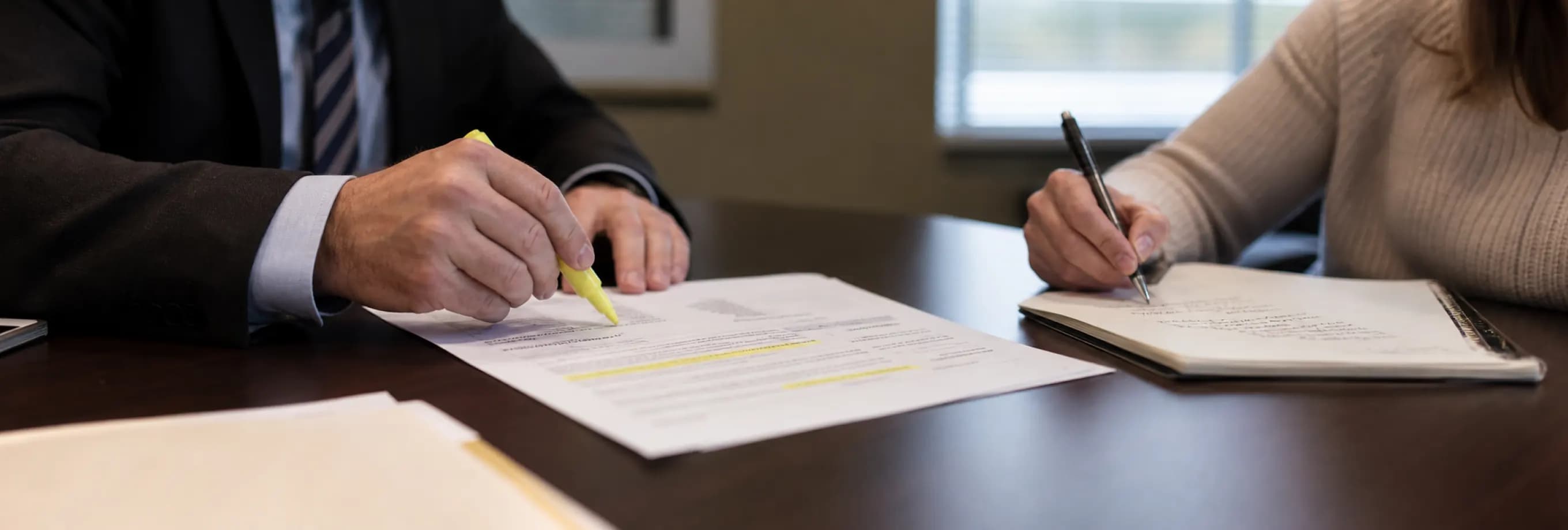An attorney marking specific findings in a custody minute order while a client takes notes